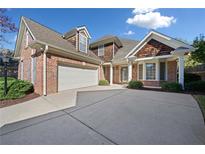 Charming two-story brick home with a large driveway and attached two-car garage at 2528 Picket Fence Ln, Snellville, GA 30078