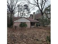 Modest single-story home with brick and siding, showcasing its potential in a mature, wooded setting at 1092 Victory Dr, Atlanta, GA 30310