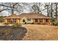 Charming brick and yellow home with a well-manicured front yard and inviting entrance at 573 Ripplewater Sw Dr, Marietta, GA 30064