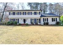 Charming two-story home boasts a classic white exterior and a well-manicured front yard at 1643 North Springs Dr, Dunwoody, GA 30338