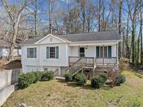 Charming two-story home with white siding, green shutters, and a welcoming front porch at 306 Birch St, Canton, GA 30114
