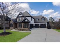 Stunning two-story home with a three-car garage, stone accents, and lush green lawn at 2077 Towne Mill Ave, Canton, GA 30114