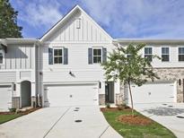 Charming townhome featuring white siding, brick accents, attached garages, and a well-maintained lawn at 4651 Larkfield Way, Powder Springs, GA 30127