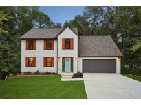 Charming two-story home with orange shutters, a gray roof, an attached two-car garage, and a beautifully landscaped yard at 1920 Rocky Mill Ln, Lawrenceville, GA 30044