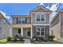 Charming two-story home featuring a stone facade, covered porch, and manicured landscaping at 847 Venture Sw Way, Atlanta, GA 30331