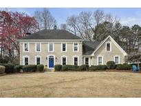 Stately two-story home featuring a manicured lawn, blue front door, and classic architectural details at 1059 Redstone Ln, Dunwoody, GA 30338