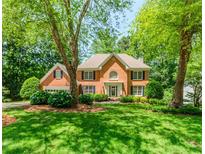 Charming two-story red brick home with manicured lawn and mature trees at 2205 Parliament Dr, Lawrenceville, GA 30043