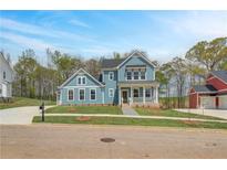 Charming blue two-story home with a welcoming front porch and manicured lawn at 4041 Andover Cir, Mcdonough, GA 30252