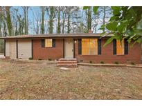 Charming red brick single-story home with a cozy front yard and freshly painted trim at 6852 Old Beulah Rd, Lithia Springs, GA 30122