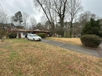Charming single-story home with a long driveway and mature trees in a natural setting at 4227 Cheryl Ann Court Ct, Stone Mountain, GA 30083