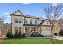 Beautiful two-story brick home with landscaped front yard, a two-car garage, and a welcoming front porch at 4270 Pleasant Woods Dr, Cumming, GA 30028