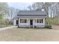 Charming exterior view of a home featuring a covered front porch, gray roof, and white siding at 2737 King Arthur Ct, Buford, GA 30519