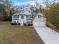 Charming two-story home with a manicured lawn and a two-car garage at 3529 Riverview Approach, Ellenwood, GA 30294