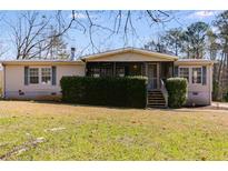 Charming single-story home featuring a cozy screened front porch and a well-maintained lawn at 4094 Yancey Rd, Douglasville, GA 30135