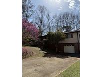 Charming home featuring a well-maintained yard, beautiful flowering tree and driveway at 719 Copper Trace Way, Woodstock, GA 30189