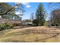 Expansive backyard with manicured lawn, pergola, and charming shed surrounded by mature trees offering shade and privacy at 3330 Habersham Rd, Atlanta, GA 30305