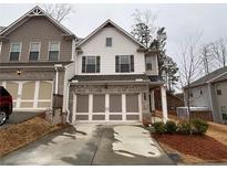 Charming two-story townhome with brick accents and a two-car garage in a well-kept community at 338 Cherryhill Ln, Woodstock, GA 30188