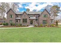Stunning two-story brick home with lush front lawn and meticulously manicured landscaping at 3338 Breton Ne Cir, Brookhaven, GA 30319