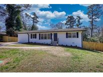 Charming single-story home with white painted brick, dark shutters and a well-manicured front lawn at 6751 Davidson Ct, Lithonia, GA 30058