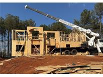 Framing of new two-story home with a crane and a stacked stone foundation at 254 Lotus Ln, Covington, GA 30016