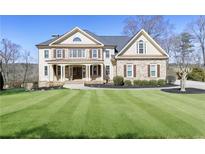 Charming two-story home featuring a manicured lawn, brick facade, and inviting front porch with columns at 3433 Pinemont Dr, Douglasville, GA 30135