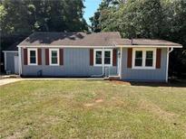 Charming single-story home features a light blue exterior, brown shutters, and a well-maintained front yard at 1766 Venetian Sw Dr, Atlanta, GA 30311