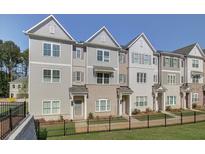 Beautiful townhome showcasing a modern exterior with gray siding and brick accents, complemented by a well-manicured lawn at 3336 Cranston Ln, Kennesaw, GA 30144