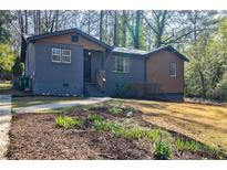 Charming bungalow showcasing a landscaped front yard and freshly painted facade at 727 Cool Hollow Dr, Decatur, GA 30033