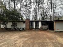 Charming single-story home with a brick chimney and ample front yard space and several bicycles at 123 Spring St, Stockbridge, GA 30281