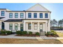 Charming two-story townhome featuring a black metal roof and eye-catching black-framed windows at 83 Arnold Poplar Ln, Auburn, GA 30011