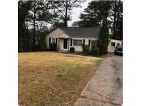 Charming single-story home featuring a well-maintained front yard with mature trees and a private driveway at 1761 Venetian Sw Dr, Atlanta, GA 30311