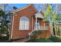 Charming brick home with a quaint front porch and mature trees at 31 Greenland Trce, Atlanta, GA 30342