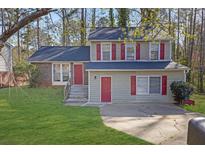 Charming two-story home with red shutters, well-manicured lawn, and inviting curb appeal at 5338 Timor Trl, Lithonia, GA 30038