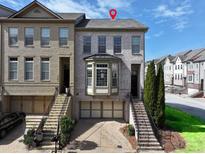 Charming townhome featuring a brick facade, bay window, and well-maintained landscaping at 2124 Silas Nw Way, Atlanta, GA 30318