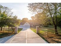 Beautiful home with a long driveway, manicured lawn, and mature trees at 770 Winding Creek Trl, Dacula, GA 30019