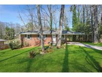 Charming brick home with a covered carport and a lush green lawn at 2664 Homeland Dr, Atlanta, GA 30360