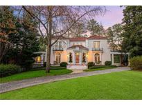 Elegant two-story white home with a red tile roof, manicured lawn, and beautiful landscaping at 401 Peachtree Battle Nw Ave, Atlanta, GA 30305