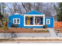 Charming blue bungalow with a cozy front porch, bright yellow door, and landscaped front yard at 674 Atlanta Se Ave, Atlanta, GA 30312