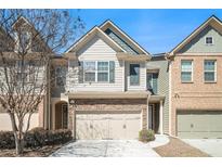 Charming townhome featuring a two-car garage and stone accents on the facade at 2398 Chancery Mill Ln, Buford, GA 30519