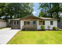 Charming bungalow with a blue front door, modern colors, and a welcoming front porch at 3235 Bluebird Ln, Decatur, GA 30032