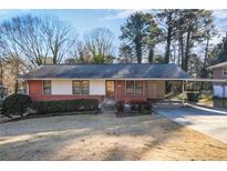 Charming one-story brick home with covered parking and a well-maintained front yard at 4676 Ridgewood Dr, Forest Park, GA 30297