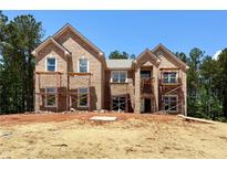 New construction of a two-story brick home featuring large windows and a classic architectural style in a wooded setting at 218 Lotus Ln, Covington, GA 30016