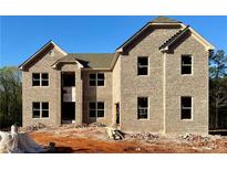 Two-story brick home featuring large windows, a modern design, and an unfinished front yard landscape at 255 Lotus Ln, Covington, GA 30016