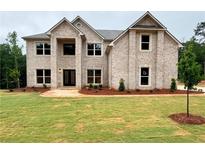 Charming two-story home features a gray brick facade, manicured lawn, and well-placed plantings at 221 Lotus Ln, Covington, GA 30016