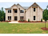 Charming two-story brick home featuring a well-manicured lawn and inviting entrance at 221 Lotus Ln, Covington, GA 30016