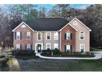 Charming two-story home featuring a brick and stucco facade, well-maintained landscaping, and a welcoming front entrance at 3920 Vine Gate Dr, Lithonia, GA 30038