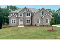 Charming two-story brick home with a well-manicured lawn and professionally landscaped yard at 211 Lotus Ln, Covington, GA 30016