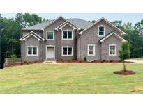 Stunning two-story brick home with a well-manicured lawn and symmetrical window design at 211 Lotus Ln, Covington, GA 30016