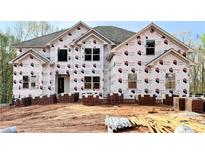 New two-story home shows the exterior elevation with newly installed windows and brick delivery on site at 211 Lotus Ln, Covington, GA 30016