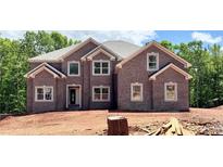 New two story home shows brick facade, double windows, and neutral trim on a sunny day at 211 Lotus Ln, Covington, GA 30016